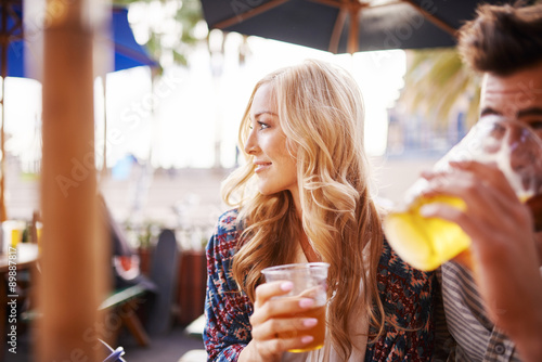 Fotografia, Obraz woman with her boyfriend enjoying drinking a beer at outdoor beach side bar or p