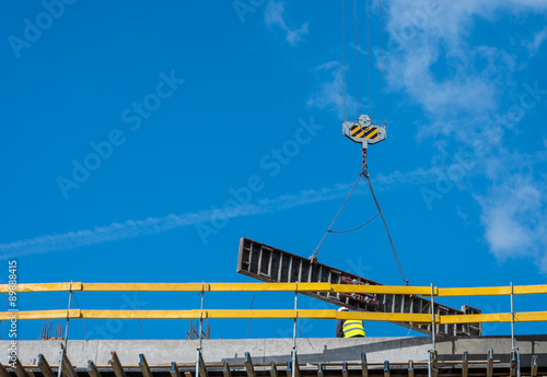 Guardrails and crane lifting formwork element on the office building construction site
