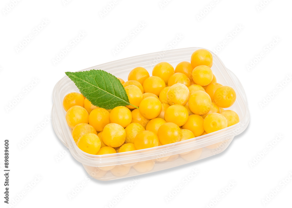 Yellow cherry plum in plastic tray on a light background Yellow cherry plum in plastic tray on a light background