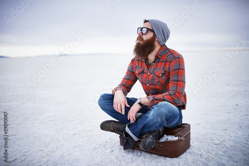 bearded hipster alone in the salt flats looking out in deep thought