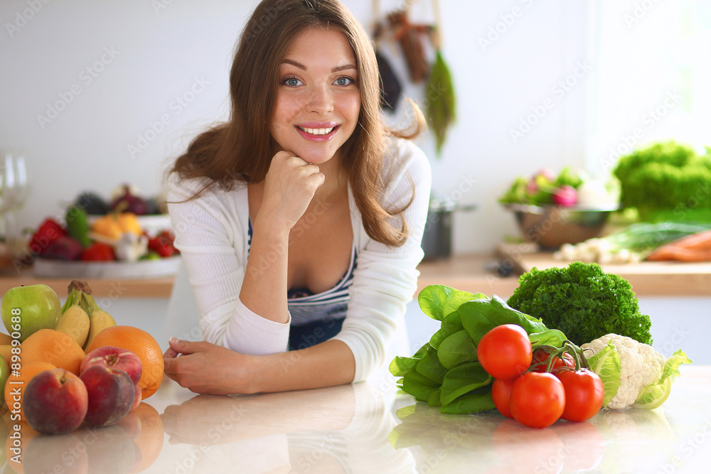 Young woman standing near desk in the kitchen Young woman standing near desk in the kitchen