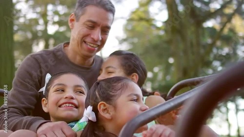 Father and his daughters sitting on a merry-go-round
