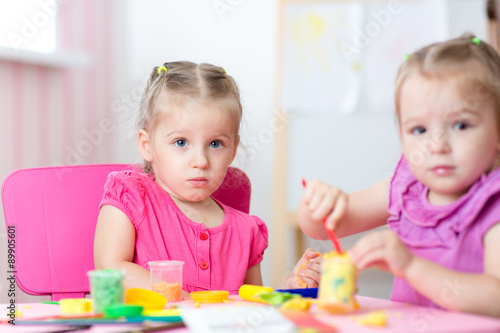 Kids playing with colorful clay molding different shapes