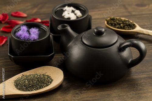 Black teapot, two cups, tea collection, flowers. Menu, recipe