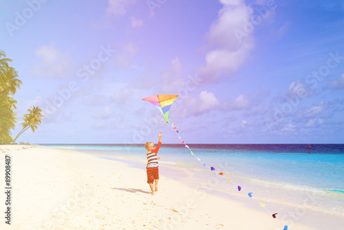 Little boy flying a kite on tropical beach