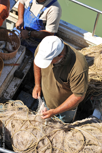 Pescador preparando las redes de pesca en el puerto pesquero