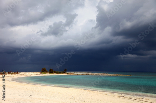 Sunny beach  dark clouds and turquoise water. Paradise Island  Bahamas