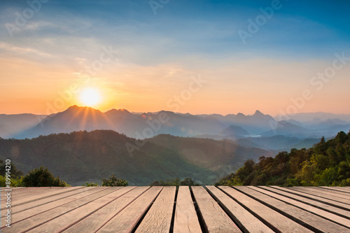 Wood table top on Majestic sunset in the mountains landscape