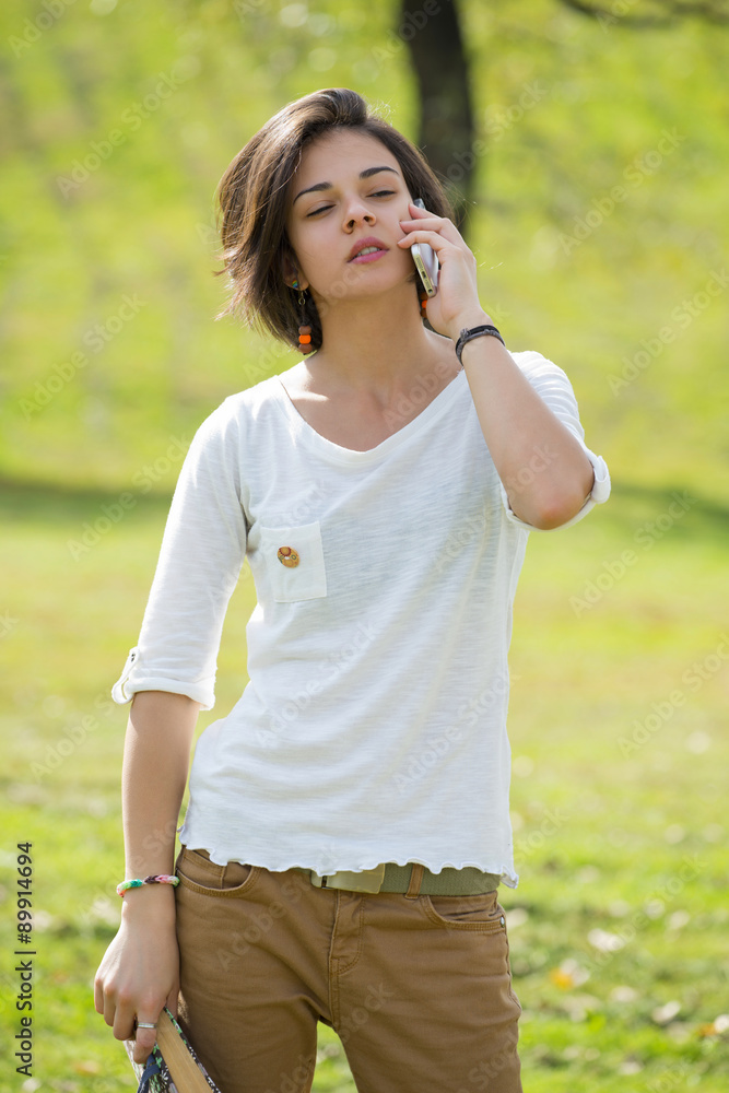 Beautiful young woman looks annoyed while talking on the phone Beautiful young woman looks annoyed while talking on the phone