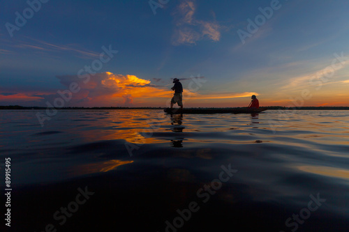 Silhouette throwing fishing net during sunrset, Thailand © JKLoma