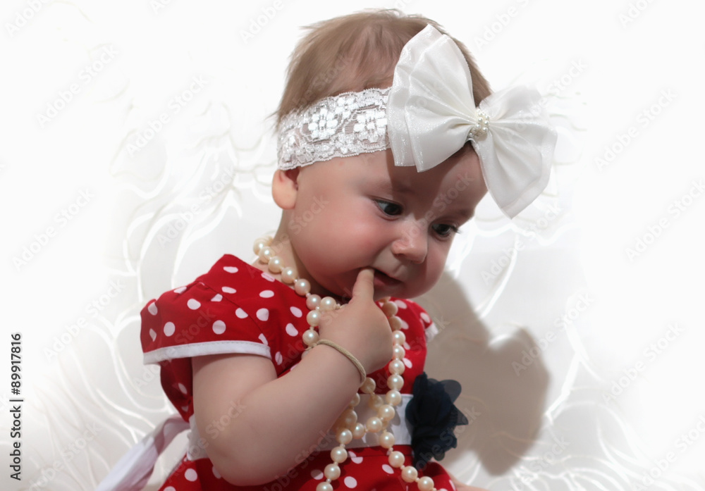 Fototapeta premium little girl in a red dress and beads