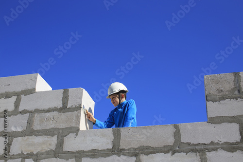 young builder. boy with a trowel in his hand playing in construction