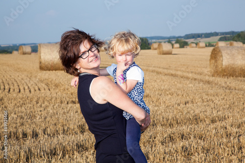 Woman with child on the field with straw bales © Edler von Rabenstein