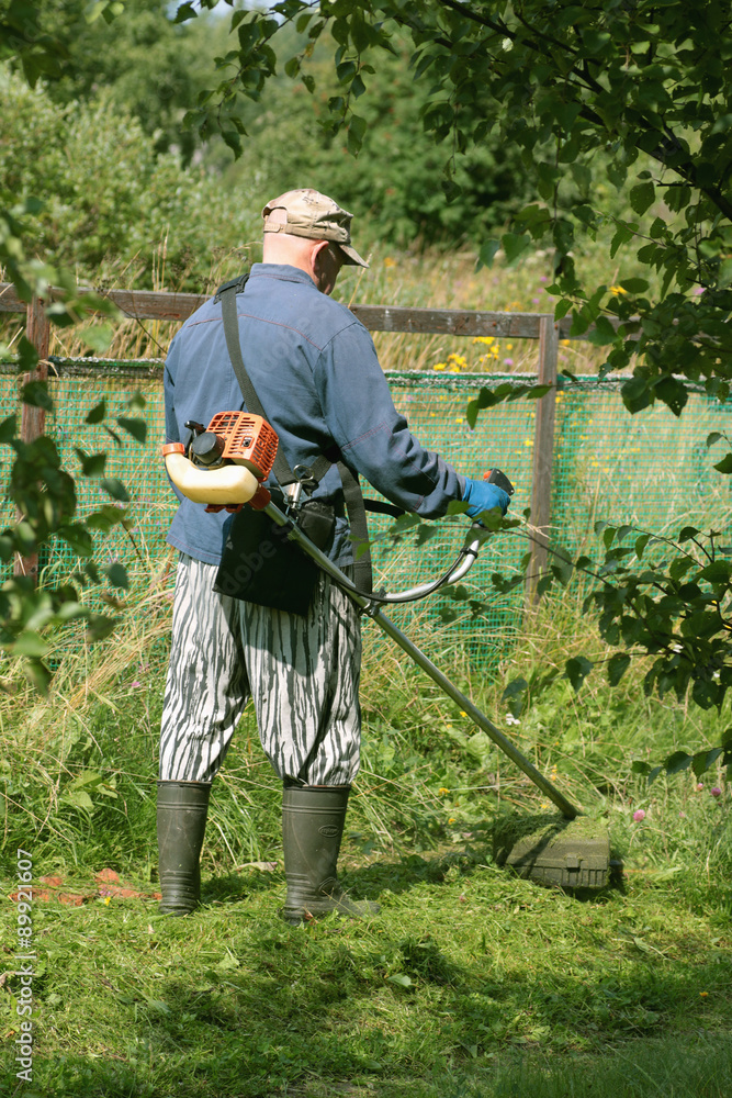 man mows the grass trimmer