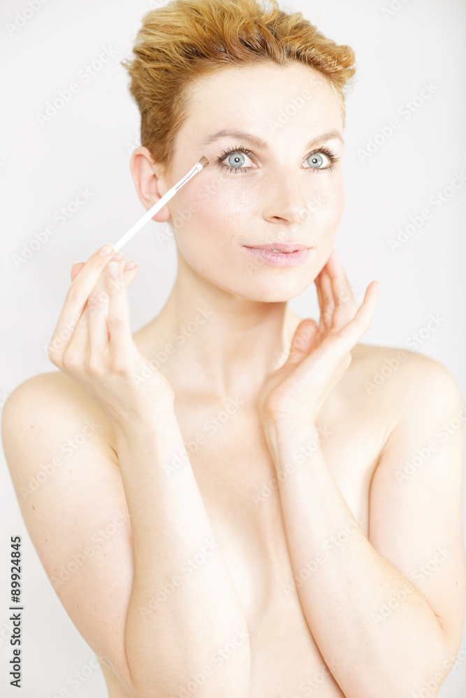 Young woman applying make up