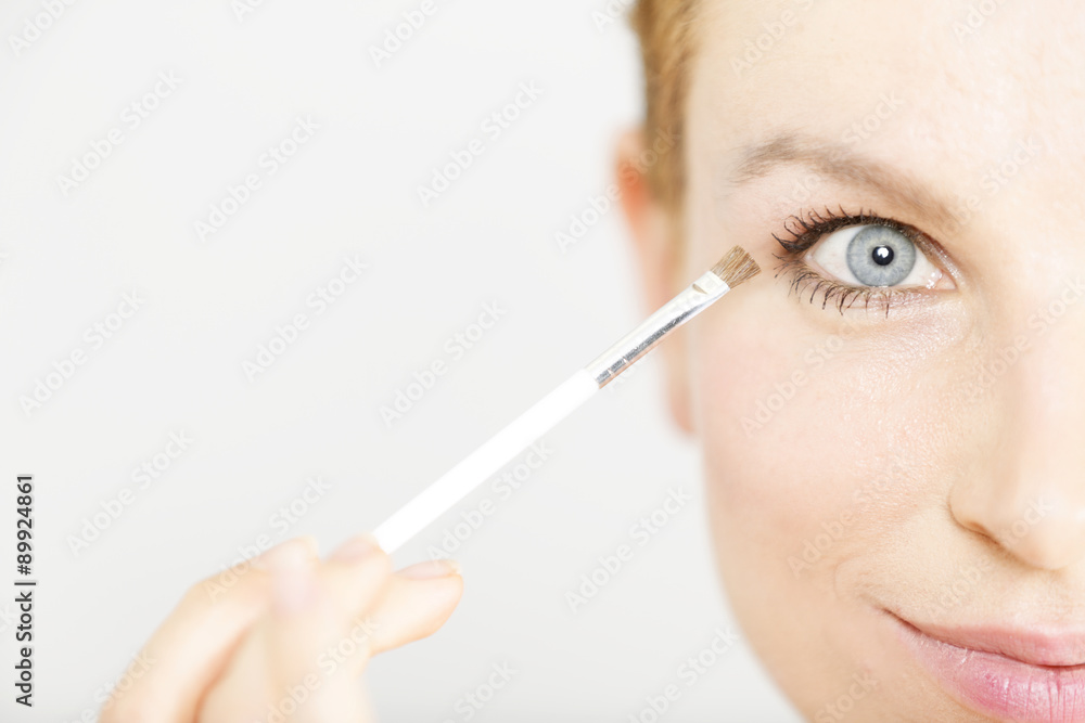 Young woman applying make up Young woman applying make up