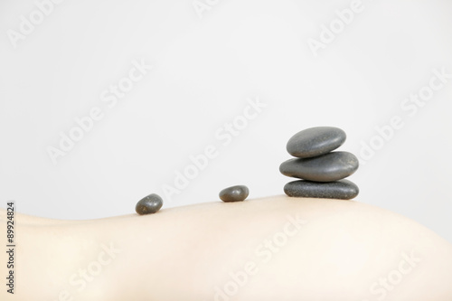 Pile of hot rocks on woman back