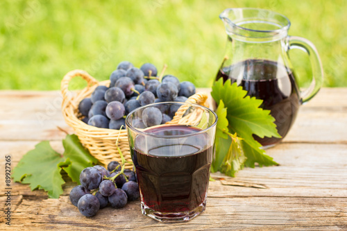 Quadro su tela Grape juice in the glass and pitcher