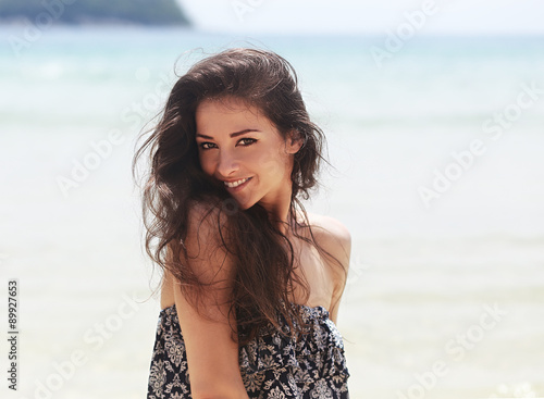 Beautiful toothy smiling woman joying on blue sea background