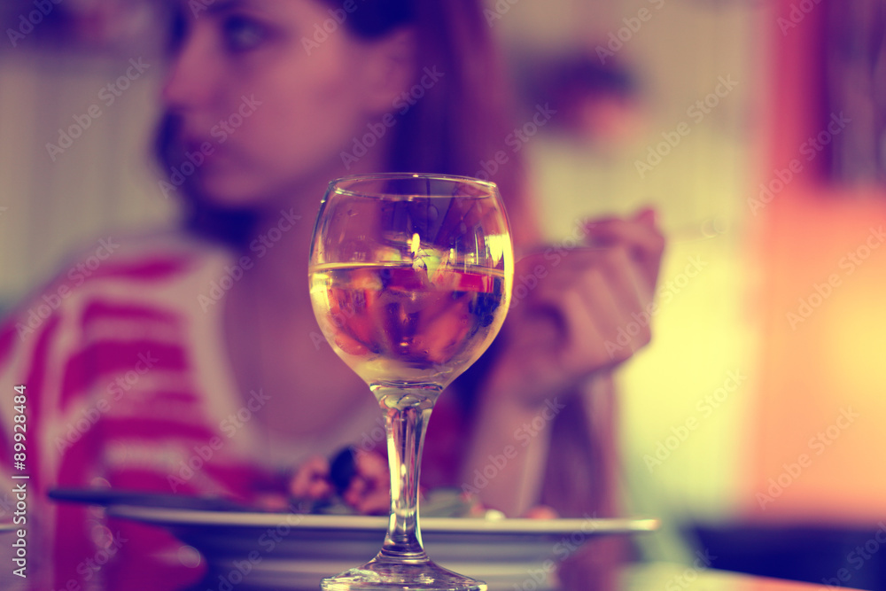 Fototapeta premium glass of white wine in a restaurant on a background of a person