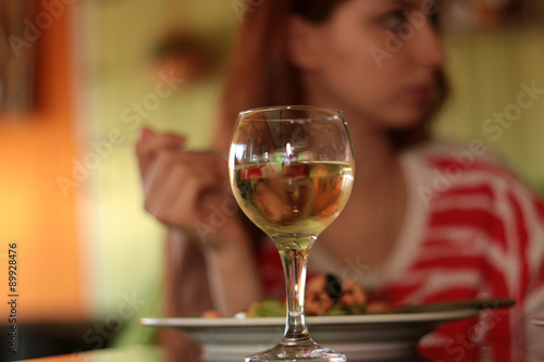 glass of white wine in a restaurant on a background of a person