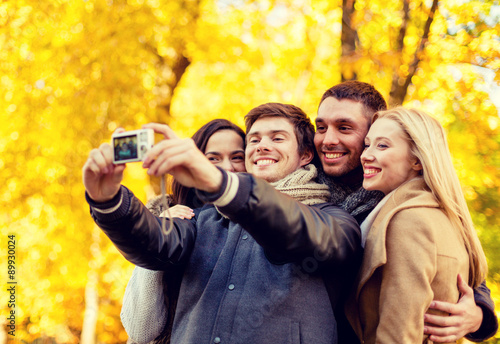 group of smiling men and women making selfie