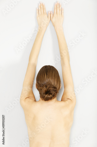 Topless woman leaning against wall
