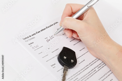 femme signant contrat de vente d'une voiture d'occasion photo