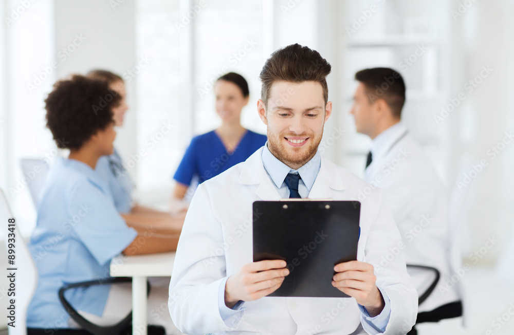 happy doctor with tablet pc over team at clinic happy doctor with tablet pc over team at clinic
