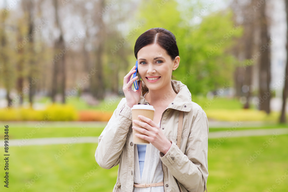 smiling woman with smartphone and coffee in park smiling woman with smartphone and coffee in park