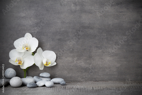 Fototapeta Naklejka Na Ścianę i Meble -  White orchid and spa stones on the grey background.
