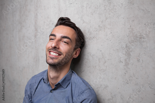 laughing man leaning on wall