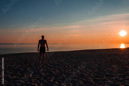 silhouette of man staring at the sea at sunset