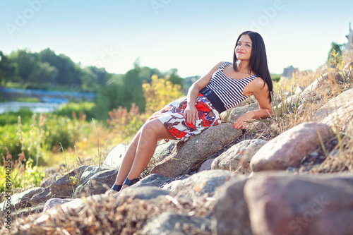 девушка сидящая на камнях у реки