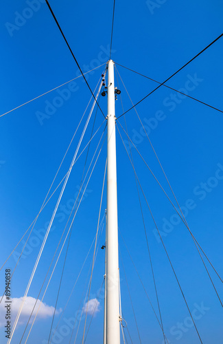 The mast of the ship on a blue sky background