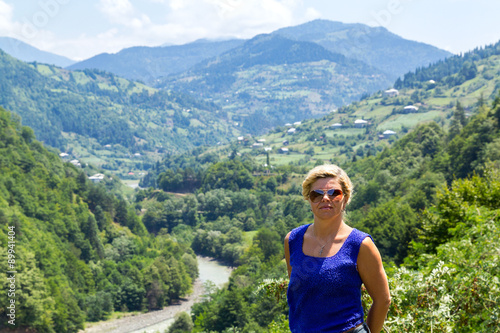 Woman in sunglasses against the backdrop of a mountain pass
