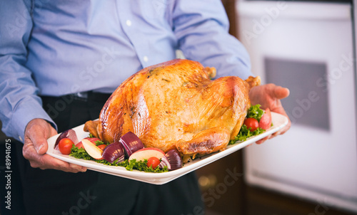 Thanksgiving: Grandfather Bringing Roast Turkey To Dinner Table
