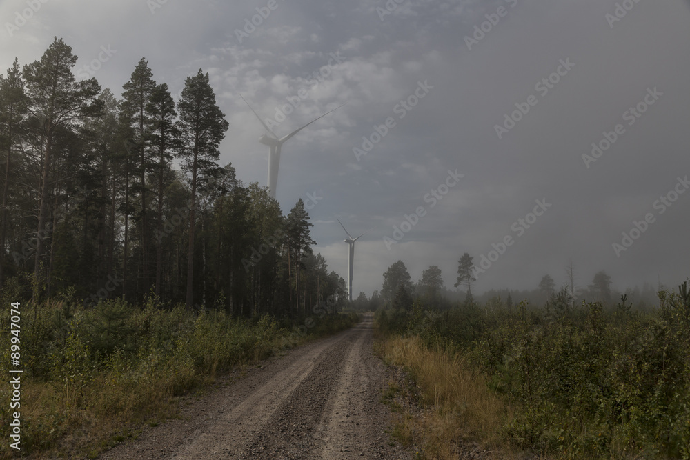 Fototapeta premium Two turbines on a road with foggy conditions