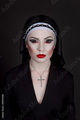 Halloween. Girl dressed in evil sexy nun