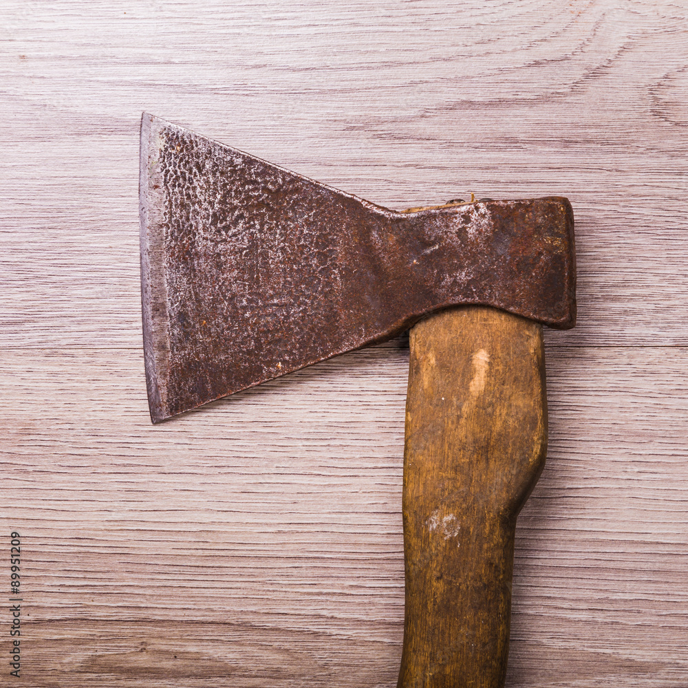 Old and dirty axe on wood background