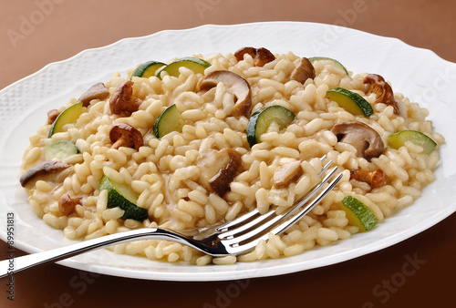 Dish of mushroom zucchini risotto with fork