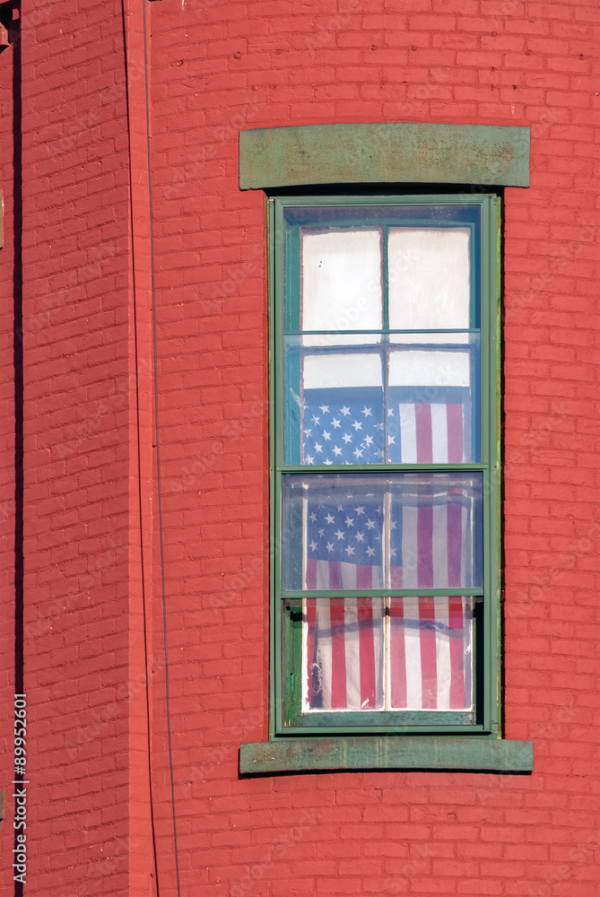 United States Flag Hanging in Window on Red  Brick House