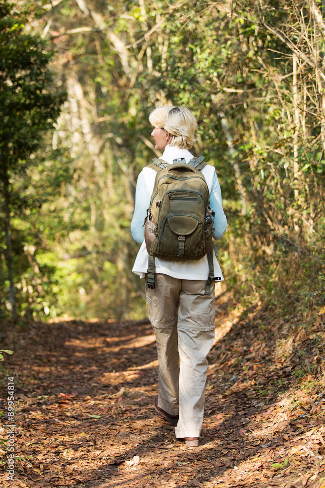 senior female hiker walking in forest