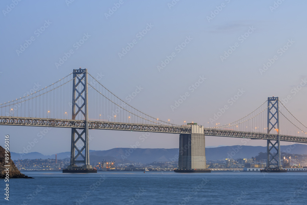San Francisco – Oakland Bay Bridge with lights at sunset time