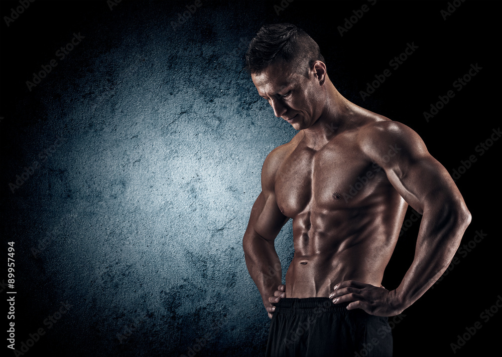 Fototapeta premium Muscular man in studio on dark background