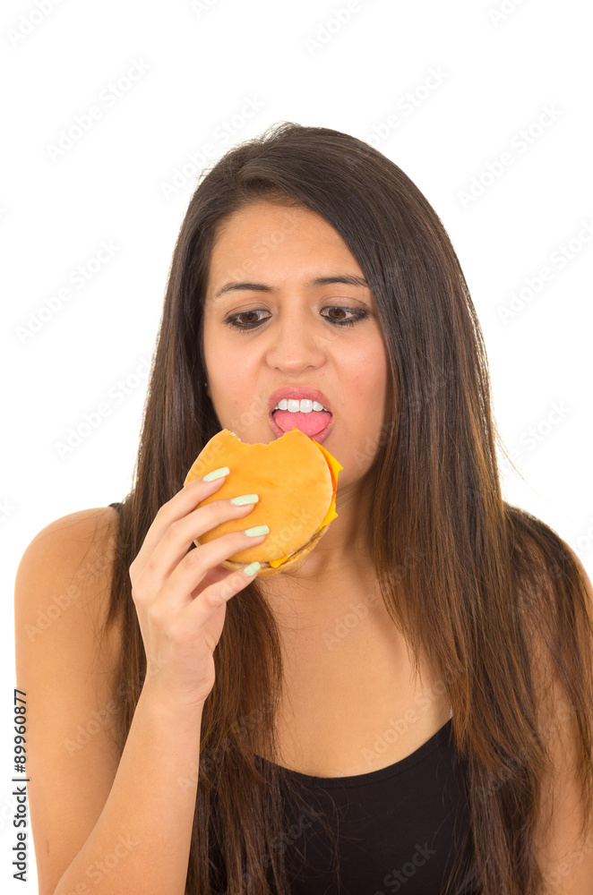Hispanic brunette model wearing black top eating hamburger Hispanic brunette model wearing black top eating hamburger