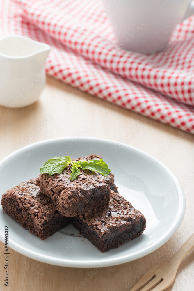 Pile of brownies on white dish.