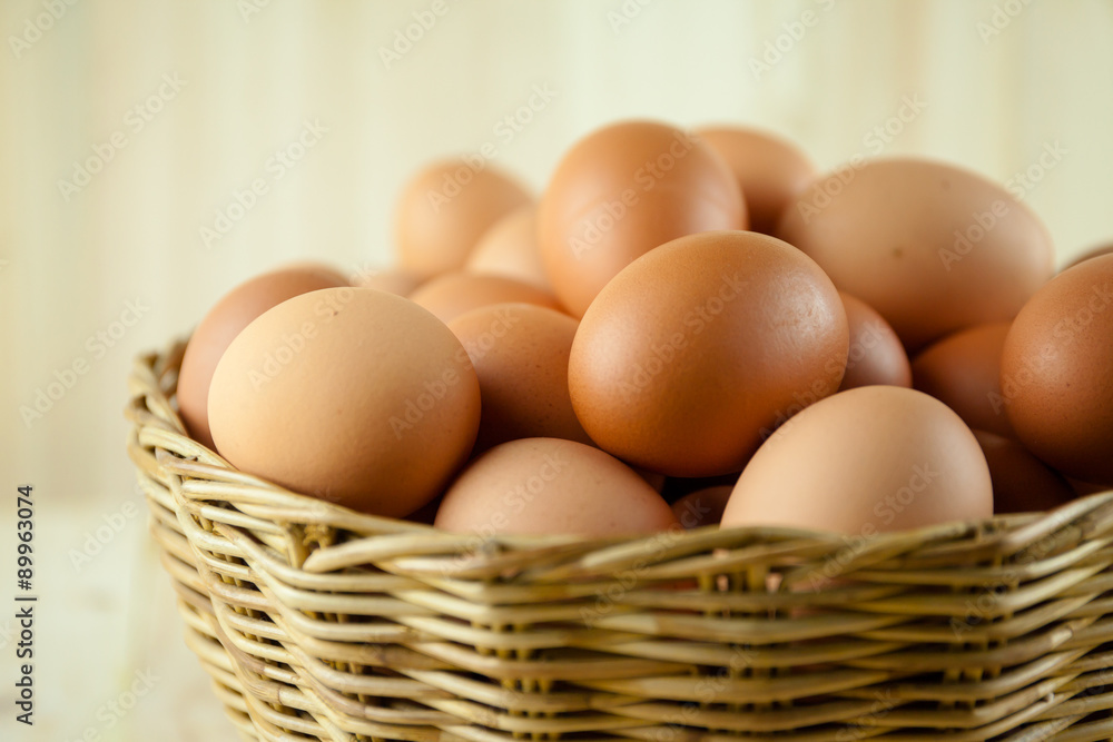 Full of Eggs put in a wicker basket in wooden background Full of Eggs put in a wicker basket in wooden background