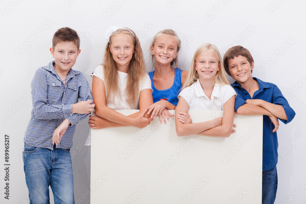Happy smiling group of kids, boys and girls, showing board Happy smiling group of kids, boys and girls, showing board