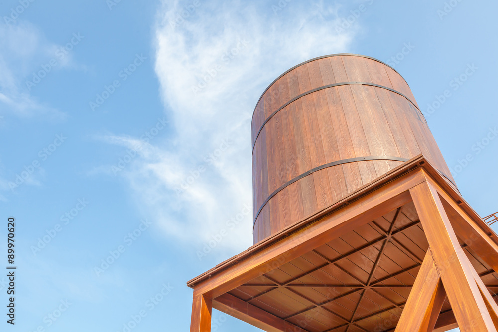 Retro style  wooden water tower over the blue sky background.